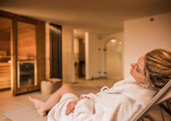 A woman is lying on a deck chair in the relaxation room