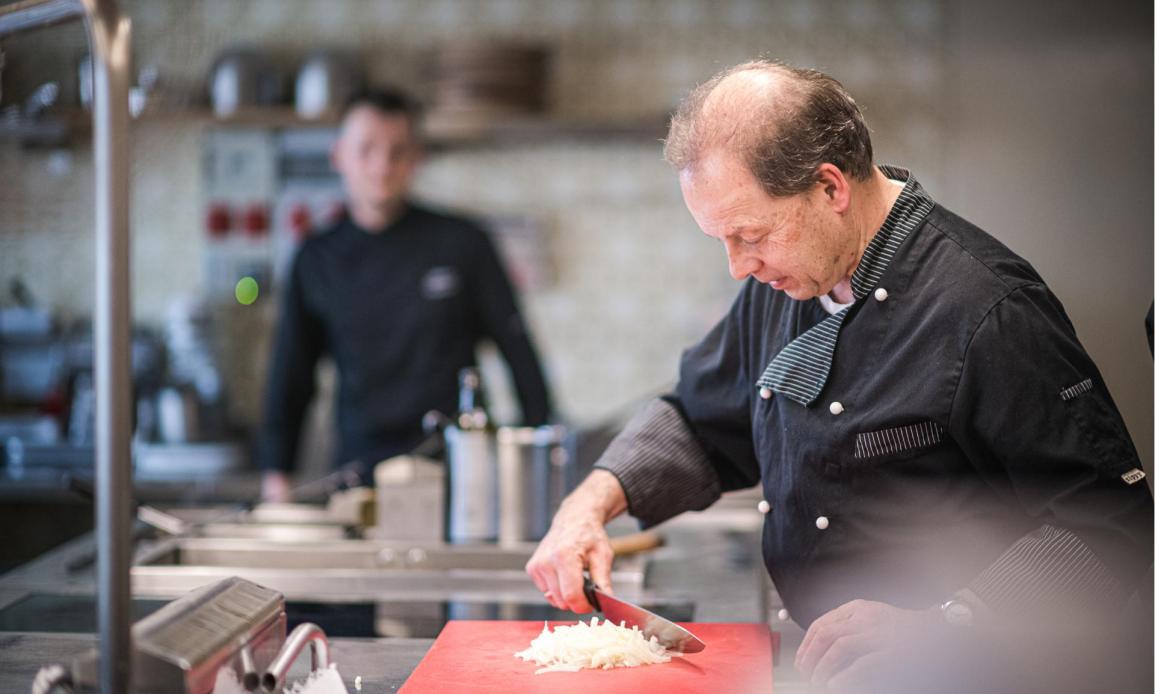 Un cuoco sta tagliando le cipolle in cucina