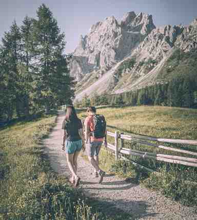 A man and a woman hiking in the Dolomites