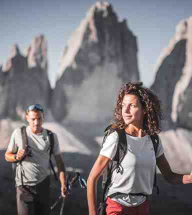 A man and a woman hiking in the Dolomites