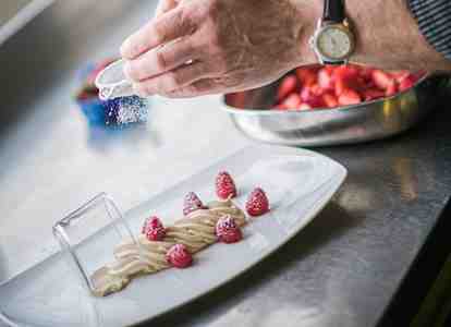 A cook is preparing a dessert.