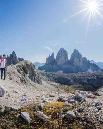 Zwei Personen beim Wandern in den Dolomiten, im Hintergrund die Drei Zinnen