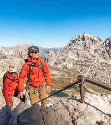 Two men are climbing a via ferrata