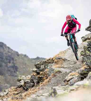 Una donna scende lungo una pista downhill con la sua mountain bike