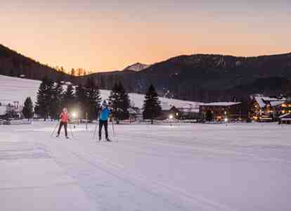 A man and a woman are cross-country skiing in the Dolomites