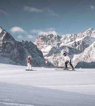 A man and a woman skiing in the Dolomites