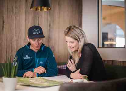 Mountain guide Christian and a woman are sitting at a table