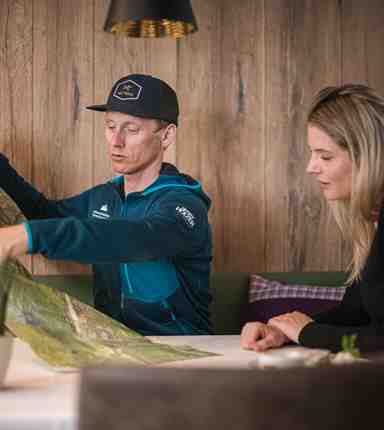 Mountain guide Christian and a woman are sitting at a table