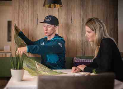 Mountain guide Christian and a woman are sitting at a table